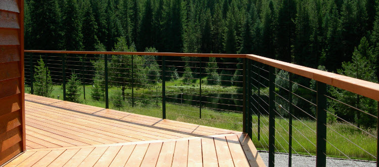 Green cable railing posts with wood hand rail.