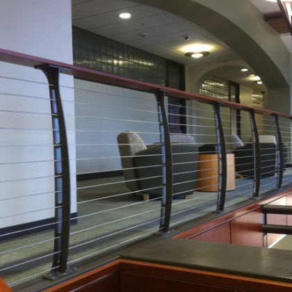 College staircase with curved cable railing and stainless steel graspable ADA railing