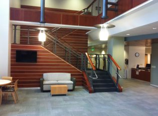 College staricase with stainless ADA handrail and teak and holly style paneling