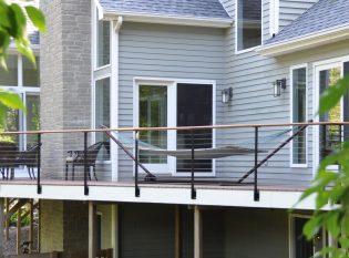 Composite wood deck with cable railing system and black posts with white trim