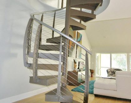 Custom made spiral staircase leading to upper level balcony