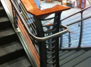 Keuka cable railing with stainless handrail, cherry banister and concrete staircase