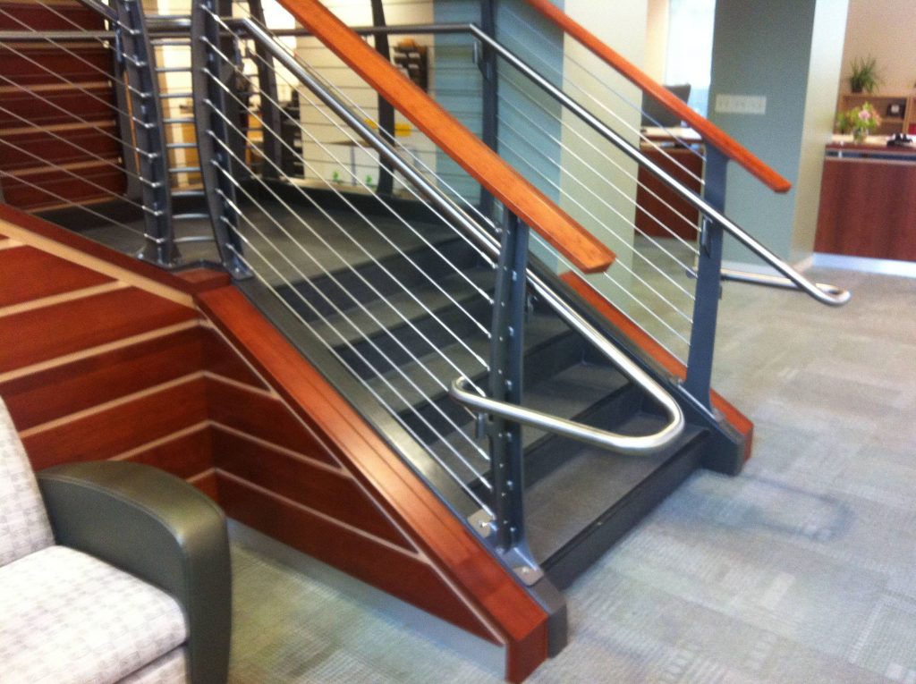 Round stainless hand rail wraps around the end post.