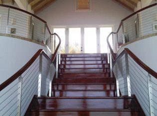 Located in Antigua Keuka Studios created this custom stainless steel railing on this grand interior staircase