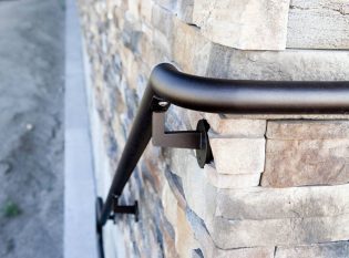 Metal handrail mounted on stone wall