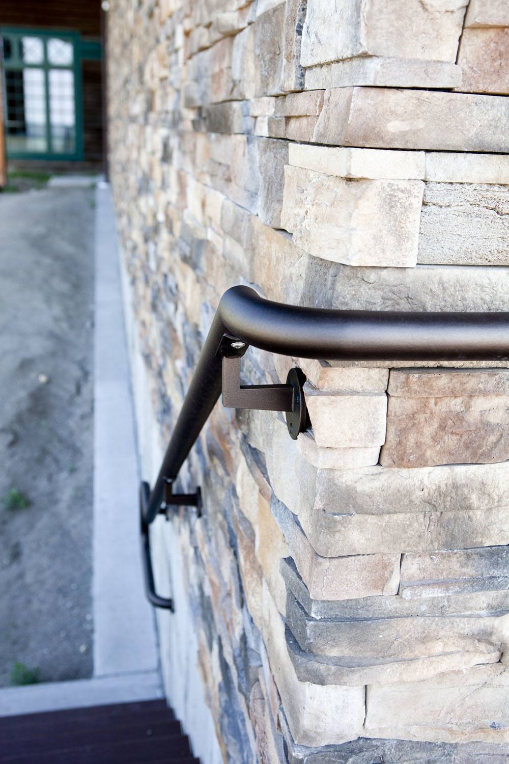 Metal handrail mounted on stone wall
