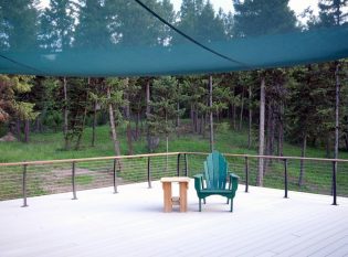 Outdoor deck featuring composite deck, sail shade and stainless cable railing