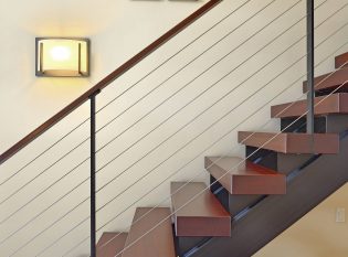 Sconce lighting on floating staircase with cherry wood treads