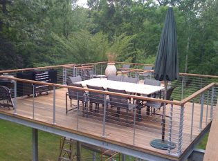 Simple aand Clean Lines Cable Railing For This Uniqued Deck Dining Area