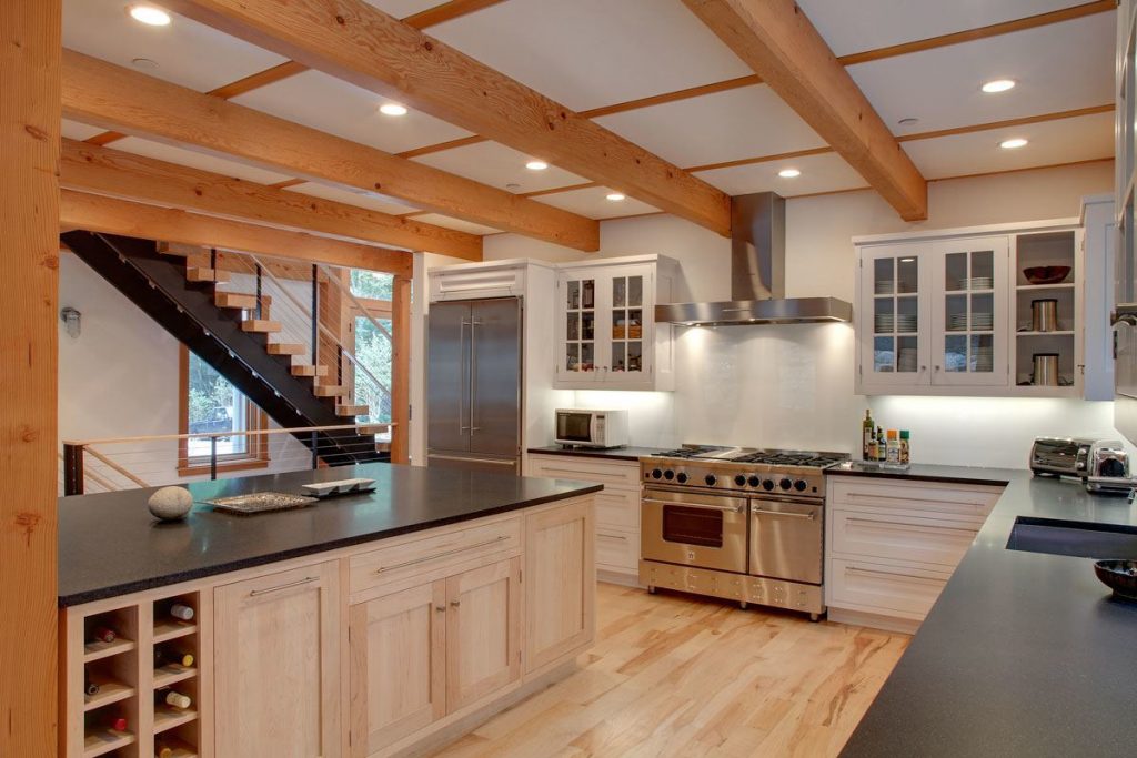 Large and spacious gourmet kitchen with heavy wood ceiling beams. And floating double stringer staircase with thick wood treads. 