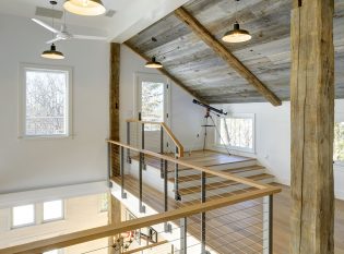 Stainless steel ithaca style cable railing on the loft looking over the living space