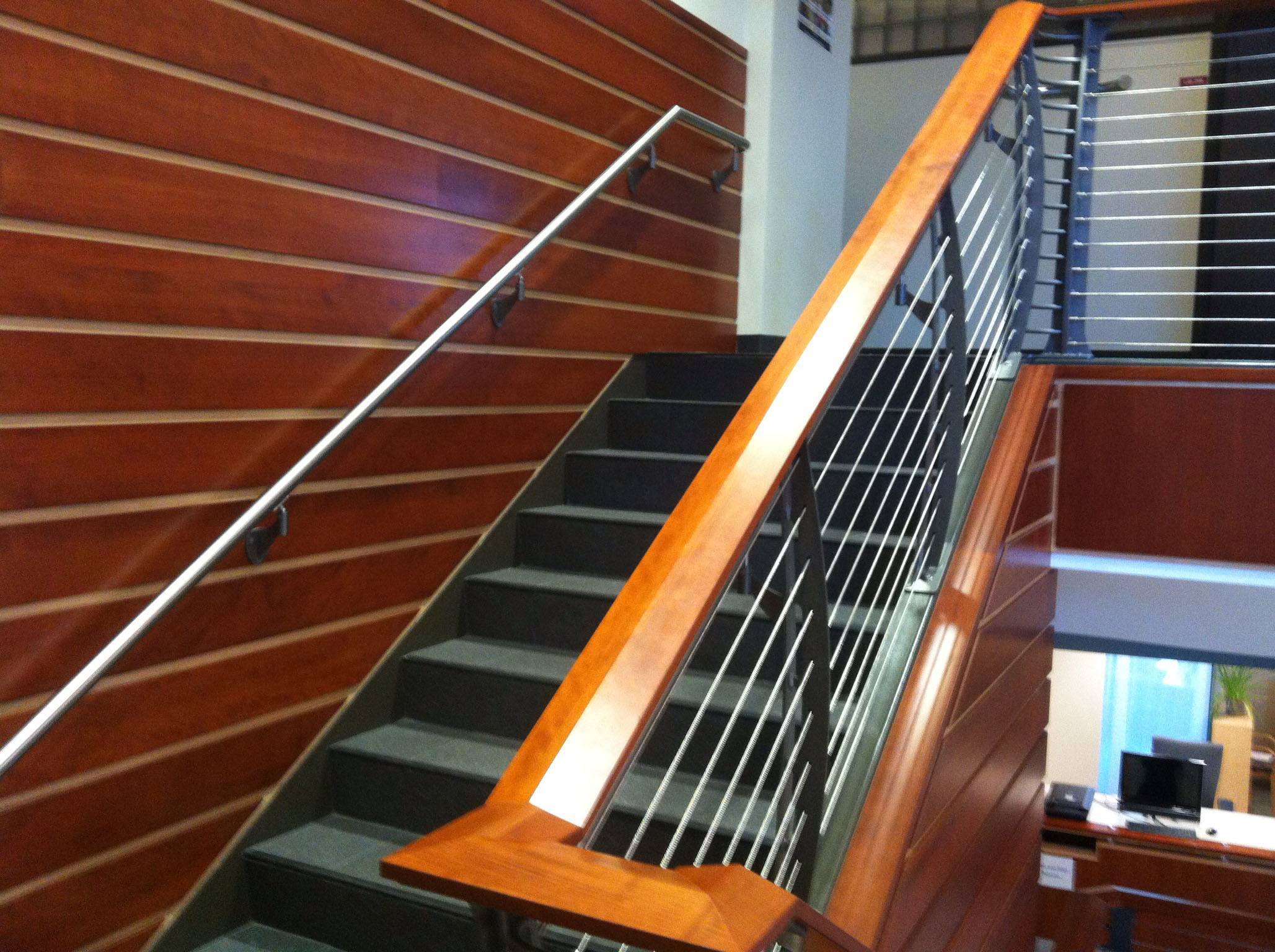 Teak and holly looking wall paneling accent this  staircase with a cherry banister