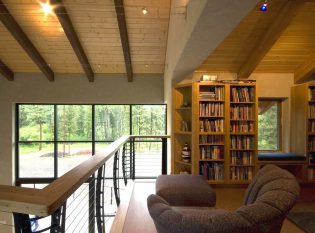 Upstairs loft with keuka cable railing overlooking living room and outdoor view