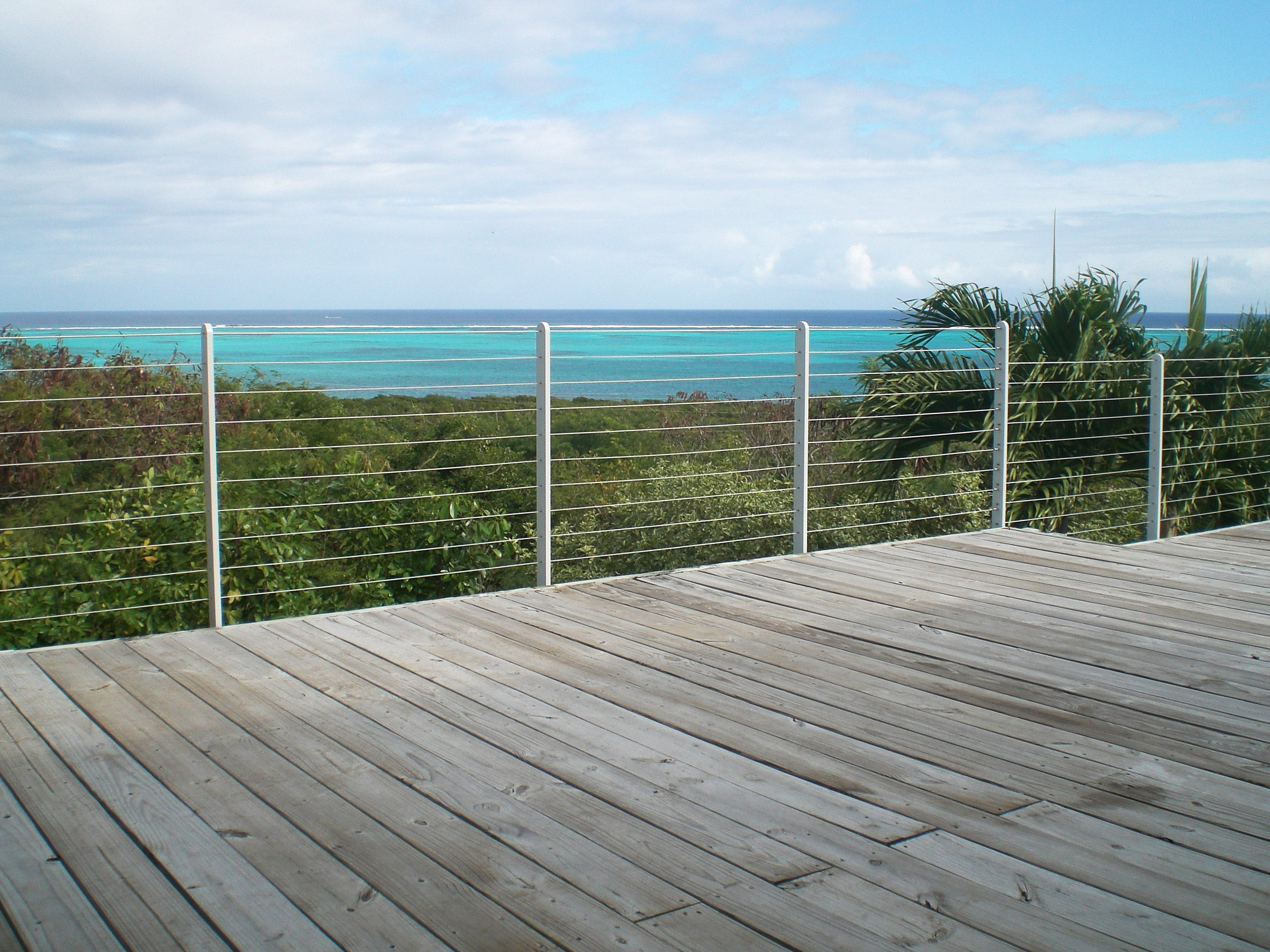View of turquoise sea through cable railing