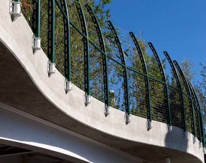 Curving pedestrian bridge railing over highway
