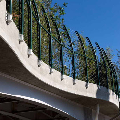 Curving pedestrian bridge railing over highway