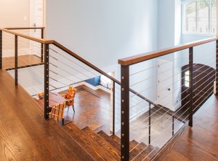 Second level foyer entry with cable railings and staircase.