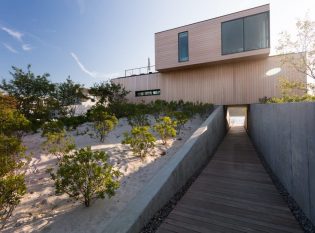 Storm surge canal running below the modern home with rooftop deck cable railings