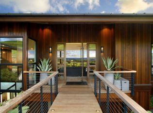 Tropical Home with bridge and cable railings leading to the main entry