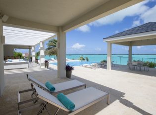 Covered porch with ocean view and cable railings