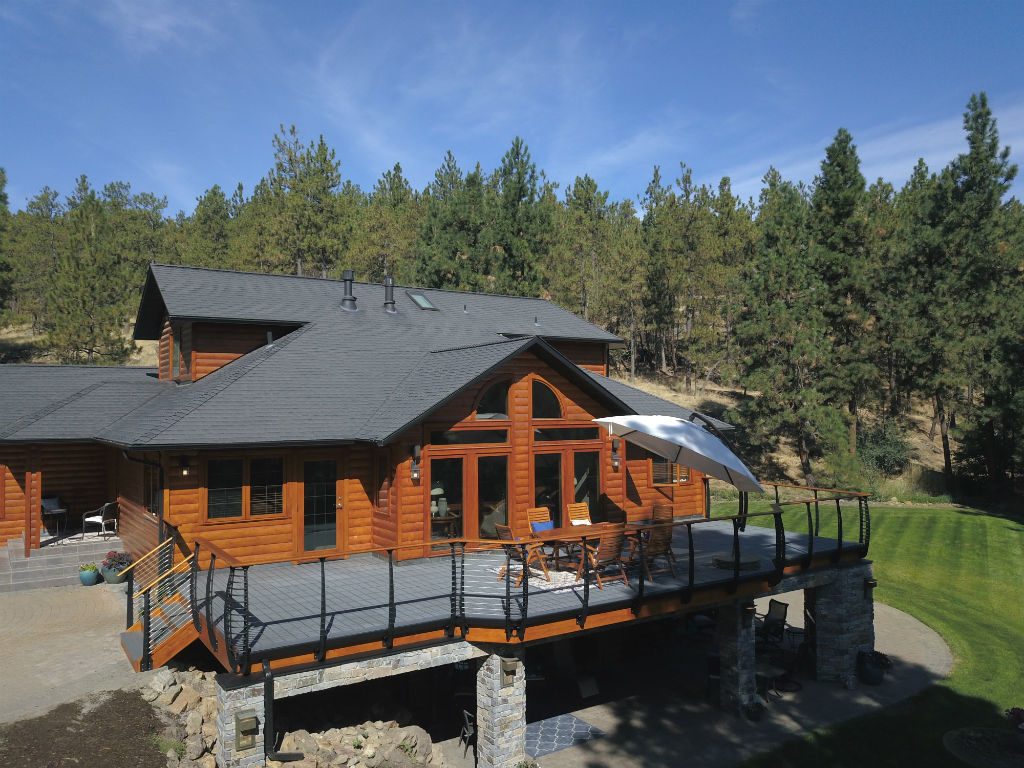 Curved deck railing on log cabin lake house