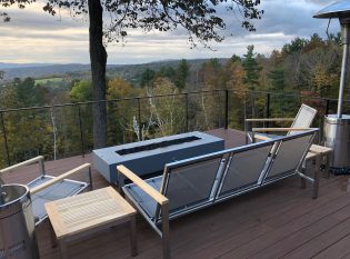 Outdoor fireplace with black deck railing