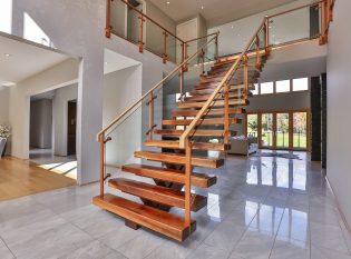 Wide mono-stringer staircase with glass railing.