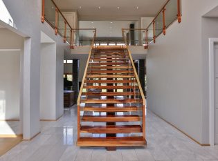 Floating mono stringer staircase with glass railing