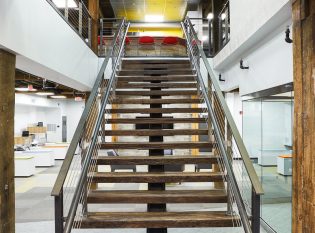 Reclaimed padauk wood and steel mono-stringer staircase.