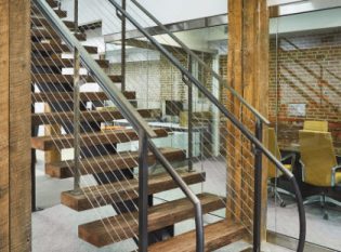 Custom mono-stringer staircase with reclaimed wood treads and clear matte coated steel stringer and railing.