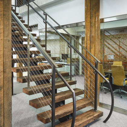 Custom mono-stringer staircase with reclaimed wood treads and clear matte coated steel stringer and railing.