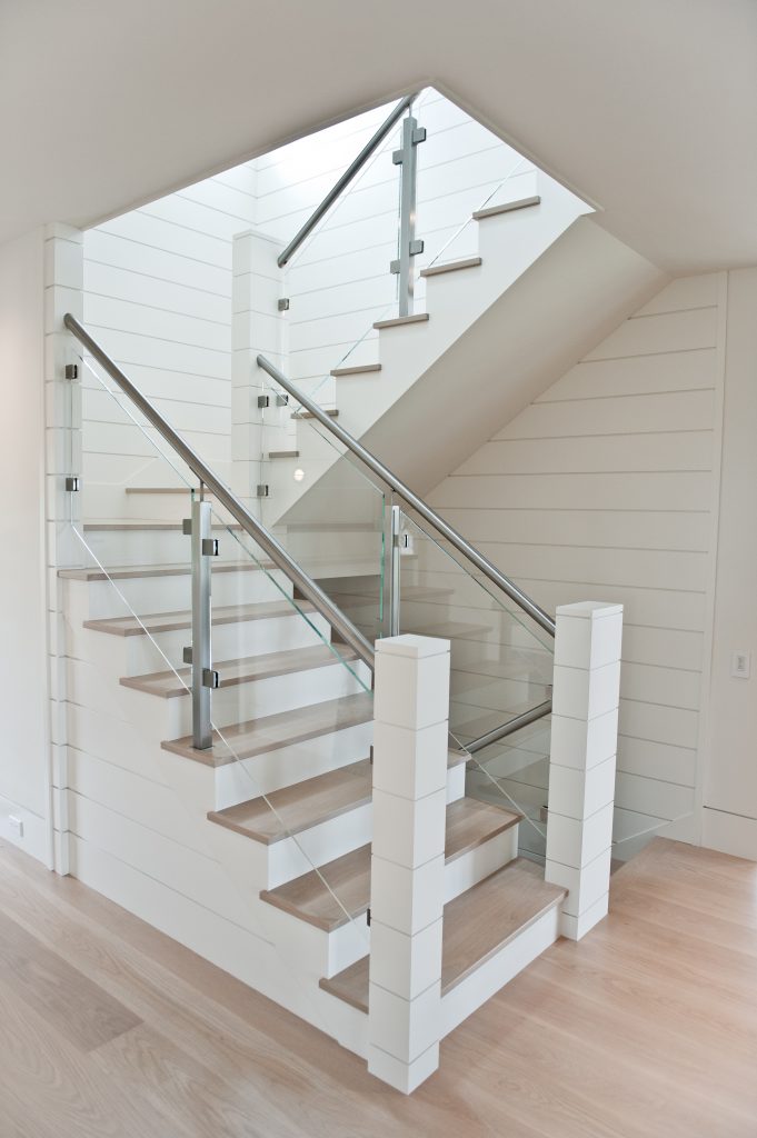 Custom stairs with wood treads, glass railing, and custom posts