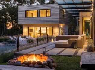 Evening campfire with stone patio and cable railing