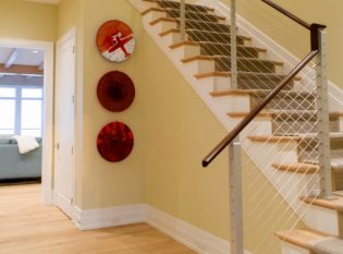 Beach house interior stairs with cable railing and dark wood top rail. 