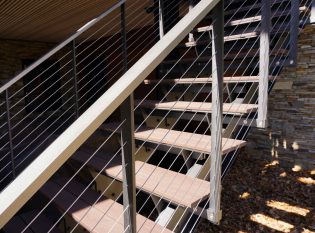 Modern floating staircase with custom cable railing and aluminum top rail