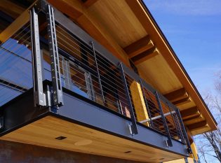 Custom fascia-mounted cable railing on timber frame home
