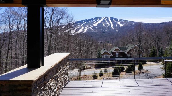 View of snowy Vermont mountains from large cable railing deck