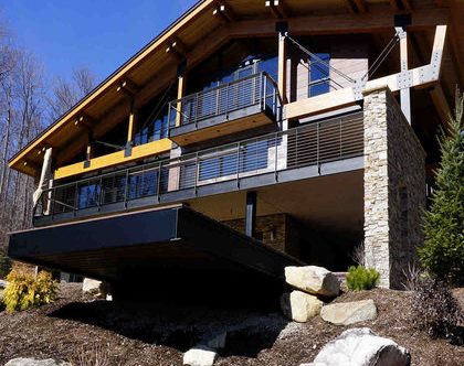 Exterior of Vermont mountain home with cable railing on deck and balcony