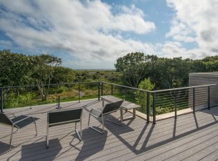 Lounge area on rooftop deck with cable railing.