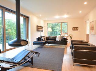 Living room interior with view through cable railing deck. 