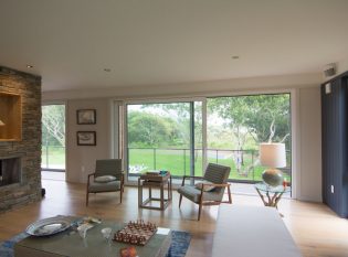 Living room with floor-to-ceiling windows and cable railing deck. 