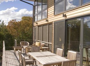 Outdoor eating are on waterfront cable railing deck. 