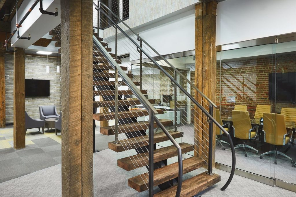Rustic floating stairs with reclaimed wood treads, and steel mono stringer. The stairs feature an ADA compliant handrail.