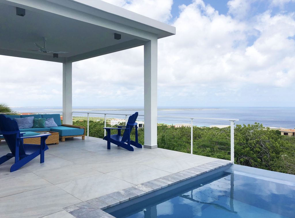 Covered relaxing outdoor space with pool and cable railing