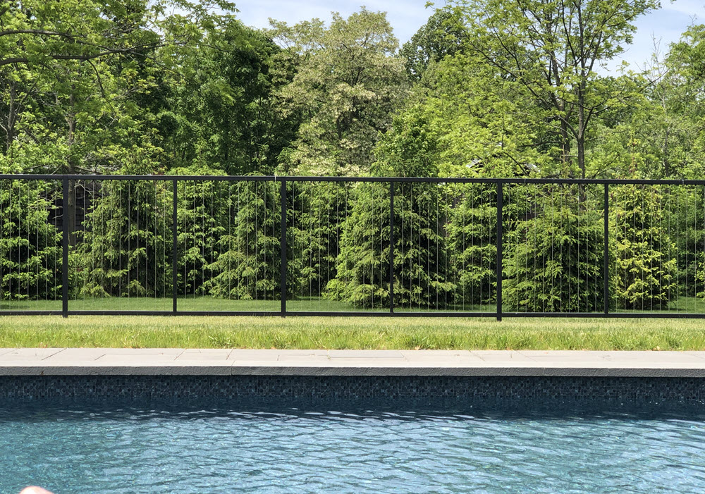 Vertical cable pool fence on lawn