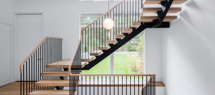 Open floating staircase allows natural light through the spindles in a home entrance.