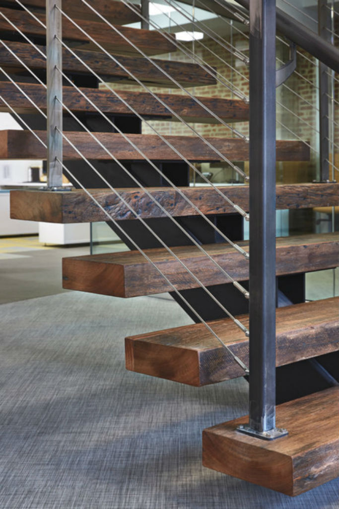 Distressed wood treads on rustic industrial staircase.