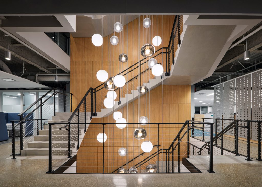 Office building lobby stairs asenc 2 levels with our sleek cable railing system and  bubble lights creating a modern and warm space.