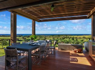 Covered dining deck with cable railing and sweeping ocean views.