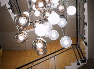 Looking up at beautiful lighting and lobby staircase